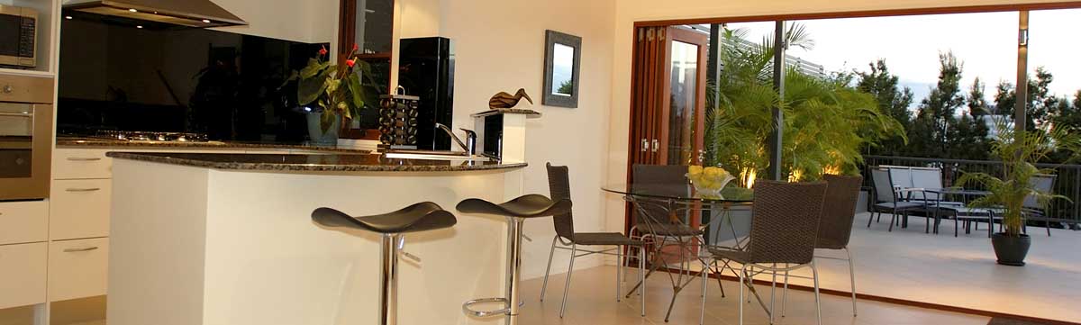 Modern kitchen with bi-fold doors leading out onto balcony